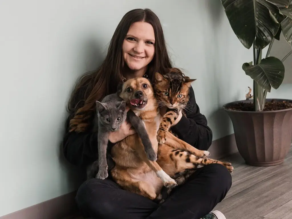 Veterinary staff holds three pets in their lap at Manchester Veterinary Services.